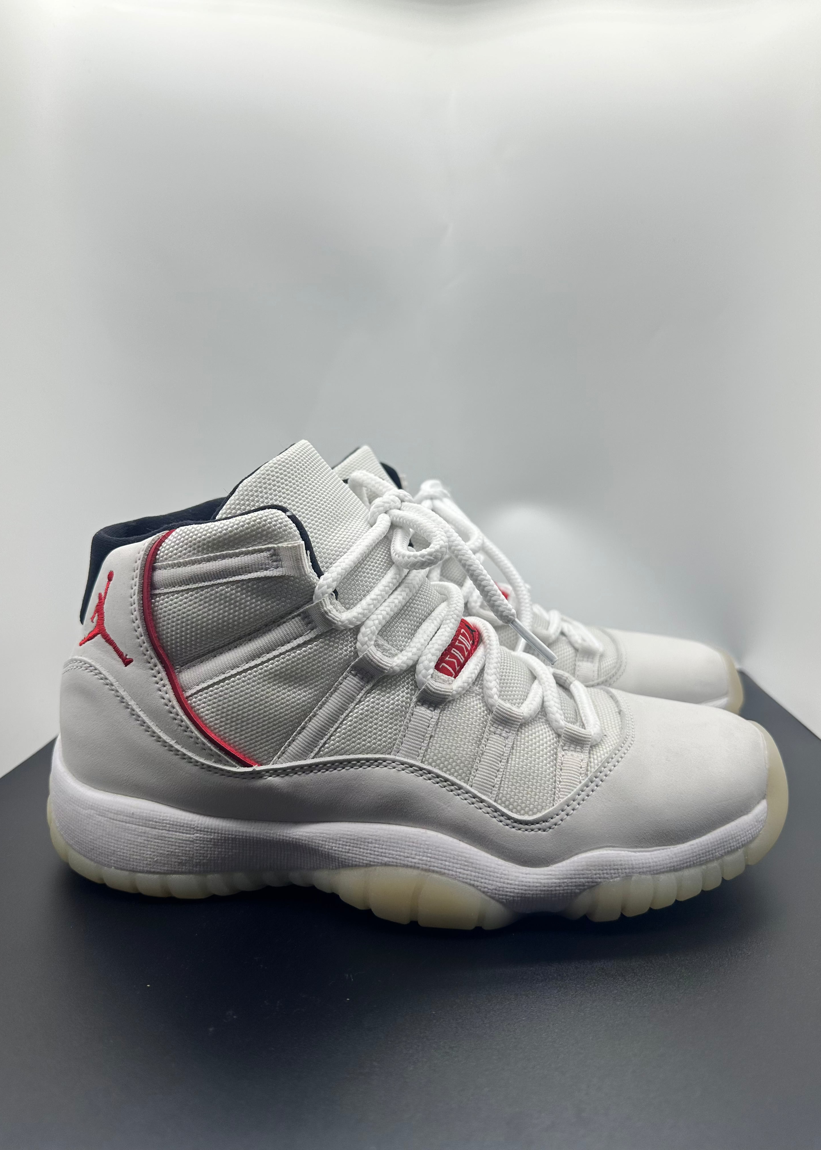 White high-top sneakers with red accents on a gray background