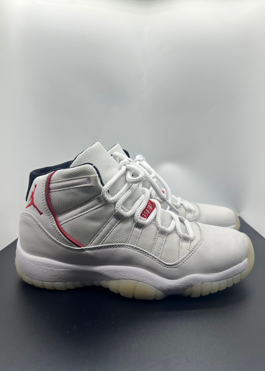 White high-top sneakers with red accents on a gray background
