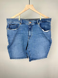 A pair of blue Levi Strauss Bermuda shorts hung on a wooden hanger against a plain background.
